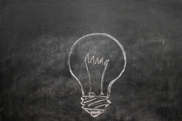 Light bulb on a black chalkboard — Stock Photo, Image