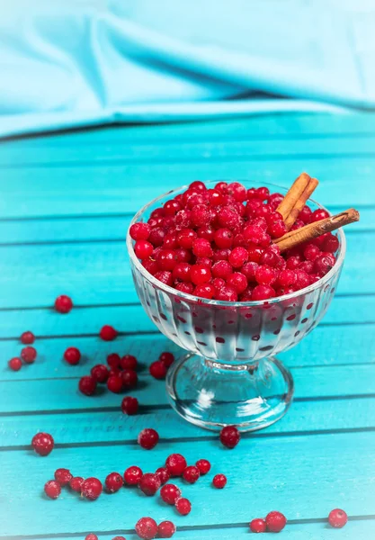 Bayas de grosella roja congeladas en un tazón de vidrio con canela — Foto de Stock