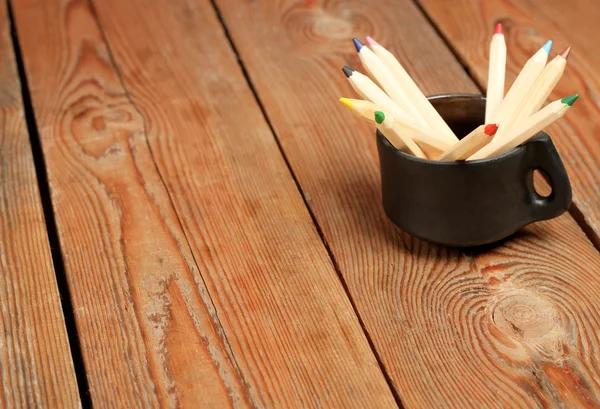 Potloden in een mok op een houten tafel — Stockfoto