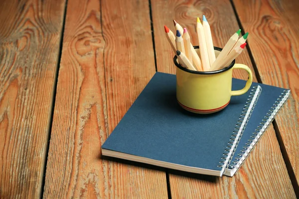 Lápices en una taza sobre una mesa de madera — Foto de Stock