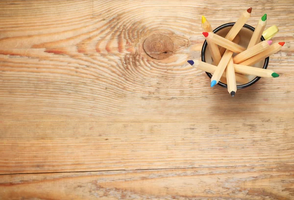 Карандаши в кружке на деревянном столе — стоковое фото