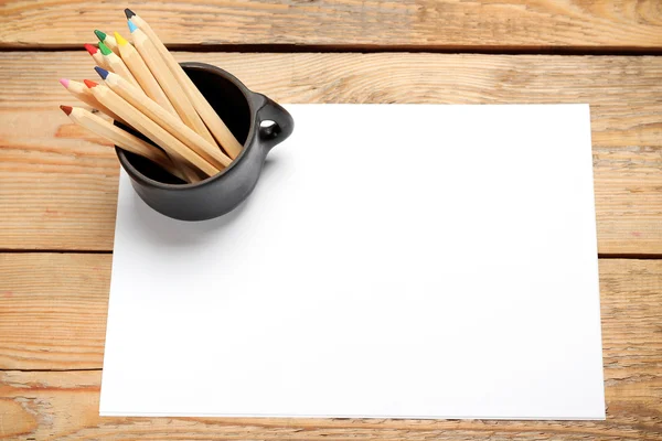 Crayons dans une tasse sur une table en bois — Photo