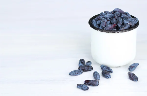Honeysuckle berries in a mug — Stock Photo, Image