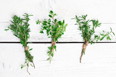 Mix of herbs on a wooden table, savory, thyme