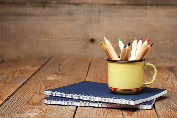 Crayons dans une tasse sur une table en bois — Photo