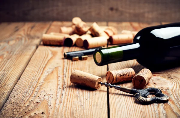 Wine corks, bottle and corkscrew on a wooden table — Stock fotografie