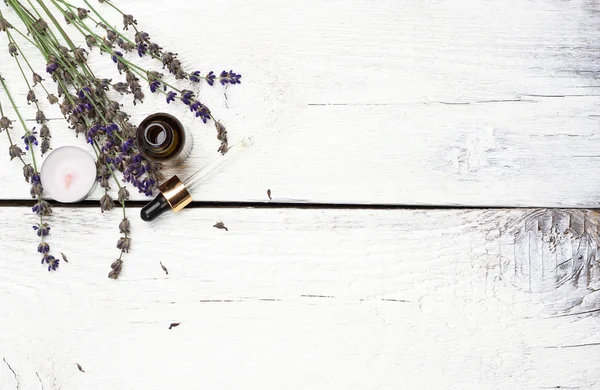 Lavanda seca e óleo sobre uma mesa de madeira branca — Fotografia de Stock