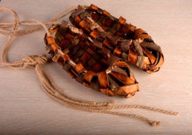 Ahşap çitin üzerindeki ayakkabılar. Eski bir hasır ayakkabının ekskonat kopyası..