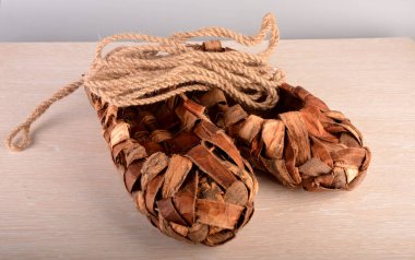 Ahşap çitin üzerindeki ayakkabılar. Eski bir hasır ayakkabının ekskonat kopyası..