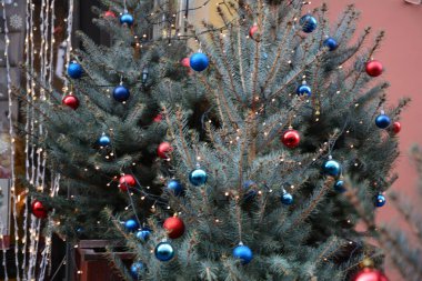 Renkli süslemeli yılbaşı ağacı. Soyut arka planda Noel süsü, süslü Noel ağacı, parlak Noel çelenkleri ve mücevherleri, yumuşak odaklı.