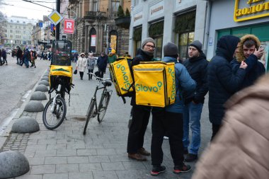 Lviv, Ukrayna - Ocak 2021: Lviv 'in merkezinde Glovo için bir kurye. Koronavirüsün yayılmasını önlemek için Ukrayna 'daki barlar, restoranlar ve alışveriş merkezleri kapatıldı.
