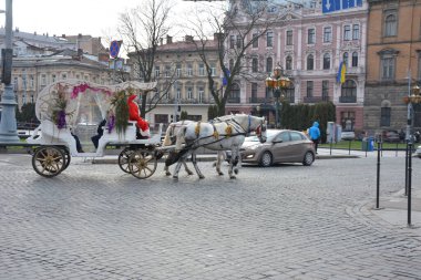 LVIV, UKRAINE - Ocak 2021. Tarihi şehir merkezindeki yolcular için turist arabası bekliyor. Lviv tarihi şehir merkezi UNESCO Dünya Mirasları Listesinde yer alıyor.