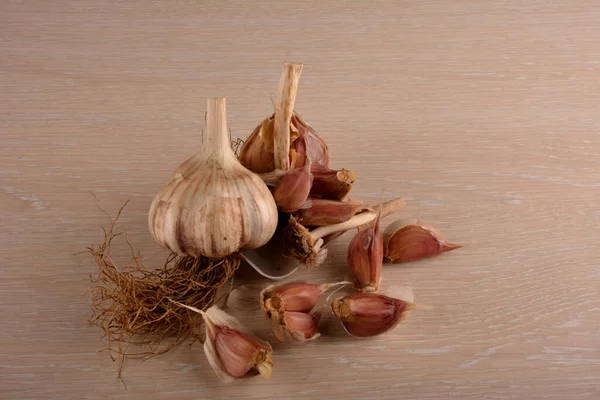 Garlic on a white background and a garlic press. Garlic grinding appliance.