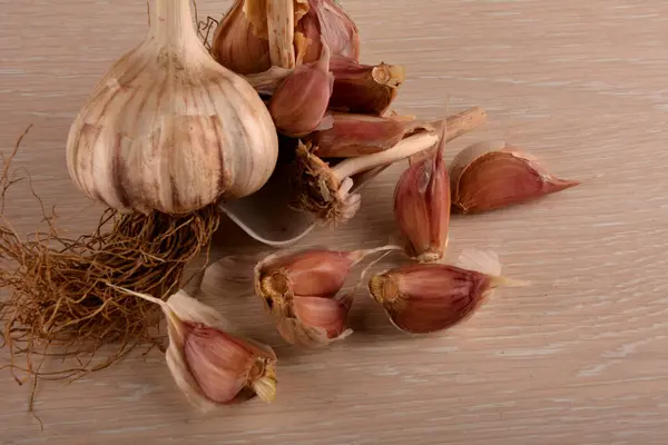 Garlic on a white background and a garlic press. Garlic grinding appliance.