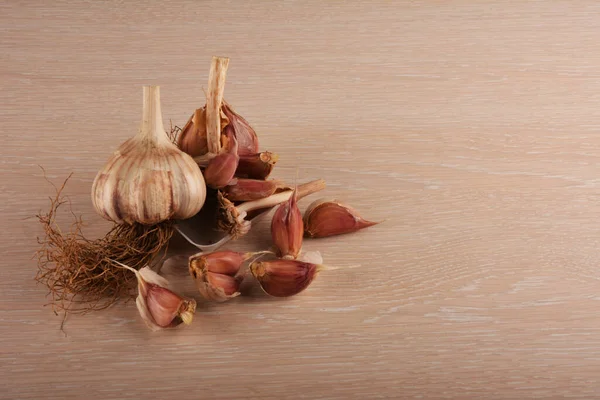 Garlic on a white background and a garlic press. Garlic grinding appliance.