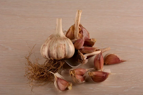 Garlic on a white background and a garlic press. Garlic grinding appliance.