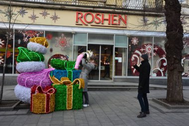Lviv. Ukrayna. Ocak 2021 'de Lviv' deki Roshen mağazasını ziyaret edenler yılbaşı günü sokak tesisi yakınlarında fotoğraflanmaktadır. Lviv 'deki 