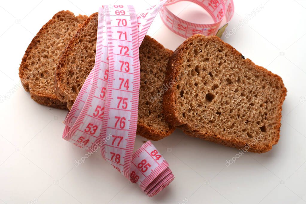 slices of bran bread with a tape measure, ideal bran bread for weight loss,Against excessive weight gain at home, bran bread, slices of bran bread and a tape measure,