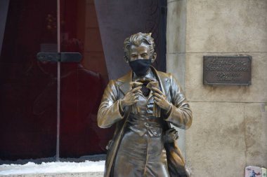 Ukrayna, Lviv -Ekim 2020. Leopold von Sacher-Masoch 'un heykeli Eski Lviv Kasabası' ndaki Cafe 'nin girişinin önünde. COVID-19 karantinası sırasında tıbbi maskeli anıt.