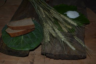 Ekmek ve tuz eski bir rustik ahşap arka planda. Ekmek ve tuz, masada buğday kulakları.