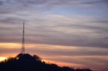 Ufukta görünen kulesi olan güzel ve renkli bir gün batımı. Fırtına ve fırtınadan önce alçalın..