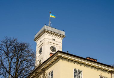 Efsaneler Evi 'nin çatısından Lviv Belediye Binası' nın muhteşem yakın çekim görüntüsü. Mavi bulutlu gökyüzü ile yaz fotoğrafı.