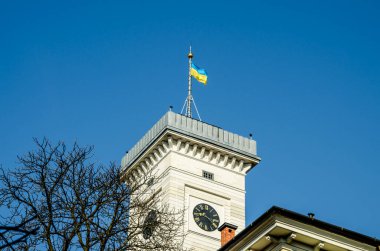 Efsaneler Evi 'nin çatısından Lviv Belediye Binası' nın muhteşem yakın çekim görüntüsü. Mavi bulutlu gökyüzü ile yaz fotoğrafı.