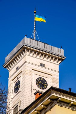 Efsaneler Evi 'nin çatısından Lviv Belediye Binası' nın muhteşem yakın çekim görüntüsü. Mavi bulutlu gökyüzü ile yaz fotoğrafı.