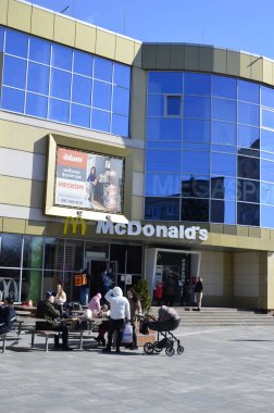 Rivne, Ukrayna - Mart 2021 Çağdaş McDonald 's Restoran Harici. McDonalds 'ın resimli başyazısı alışveriş merkezinin girişini imzalıyor. McDonald' s fast food restoranı - logolu pencere