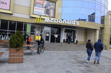 Rivne, Ukrayna - Mart 2021 Çağdaş McDonald 's Restoran Harici. McDonalds 'ın resimli başyazısı alışveriş merkezinin girişini imzalıyor. McDonald' s fast food restoranı - logolu pencere
