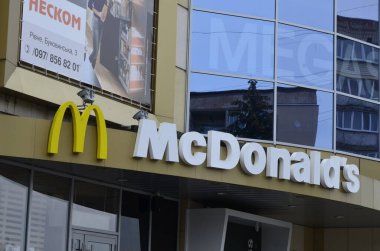 Rivne, Ukrayna - Mart 2021 Çağdaş McDonald 's Restoran Harici. McDonalds 'ın resimli başyazısı alışveriş merkezinin girişini imzalıyor. McDonald' s fast food restoranı - logolu pencere