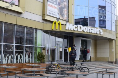 Rivne, Ukrayna - Mart 2021 Çağdaş McDonald 's Restoran Harici. McDonalds 'ın resimli başyazısı alışveriş merkezinin girişini imzalıyor. McDonald' s fast food restoranı - logolu pencere