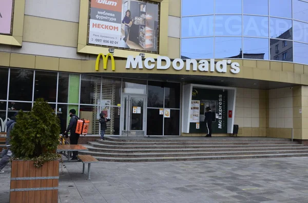 Rivne, Ukrayna - Mart 2021 Çağdaş McDonald 's Restoran Harici. McDonalds 'ın resimli başyazısı alışveriş merkezinin girişini imzalıyor. McDonald' s fast food restoranı - logolu pencere