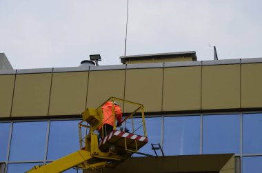 Rivne. Ukrayna. Nisan 2021 Bir otomotiv hidrolik alıcısı kullanarak yüksek binaların camlarını yıka. Yükseklikte çalış.