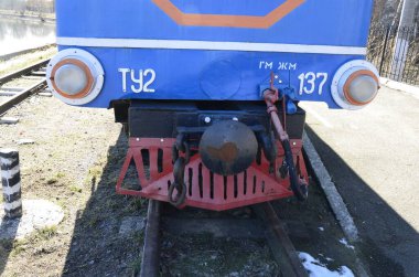 Rivne . Ukrayna. Nisan, 2021 Dar ölçülü çocuk demiryolu lokomotifinin arka planında demiryolu trafik ışıkları.