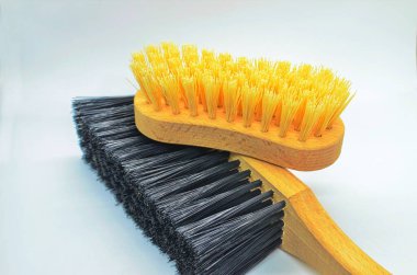 Kıyafetler beyaz arka planda fırçalanır. Giysilerdeki tozu temizlemeye yardımcı olur. Masadaki fırçalar. Kıyafet fırçası.