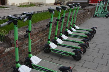Lviv. Ukrayna. Şehir sokaklarında Mayıs 2021 'de kiralık elektrikli scooter' lar. Şehirde her gün elektrikli scooter ekonomik araç kullanılıyor. Limon kiralama mobiletlerinin sokak manzarası bir iş yerinin önünde sıralanmıştı.