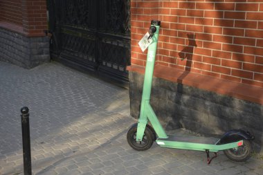 Lviv. Ukrayna. Şehir sokaklarında Mayıs 2021 'de kiralık elektrikli scooter' lar. Şehirde her gün elektrikli scooter ekonomik araç kullanılıyor. Limon kiralama mobiletlerinin sokak manzarası bir iş yerinin önünde sıralanmıştı.