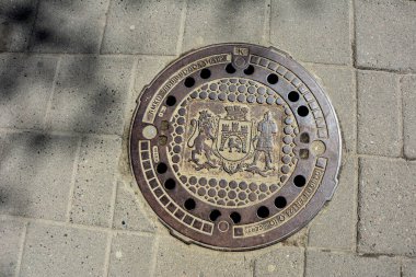 Lviv, Ukrayna. Temmuz 2021. Metal kanal kapaklı bir taş. Arkaplan dokusu olarak taş kaldırım. Taş bloklu kaldırım.