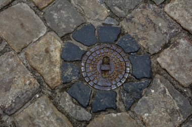 Lviv, Ukrayna. Temmuz 2021. Metal kanal kapaklı bir taş. Arkaplan dokusu olarak taş kaldırım. Taş bloklu kaldırım.