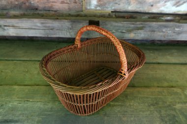 Boş bir el yapımı hasır sepet yeşil çimlerin üzerinde duruyor. Çevre dostu yaşam tarzını sembolize eden geleneksel kırsal zanaat, hasat, bahçıvanlık ve doğal kır tarzı..