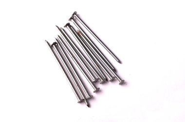 Beyaz arka planda büyük bir demir çivi yığını var.