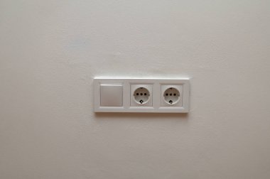 Modern beyaz duvar paneli çift Avrupa elektrik prizi ve lamba anahtarına sahip. Minimalist iç mekan, ev elektriği, ev altyapısı konsepti.