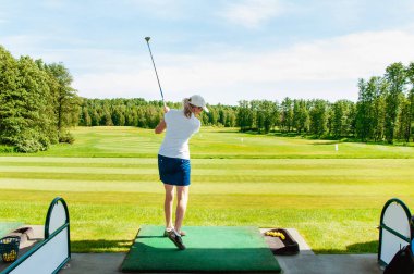 Profesyonel golf sahasında golf oyuncusu. Golf sopasıyla vuruşan golfçü.