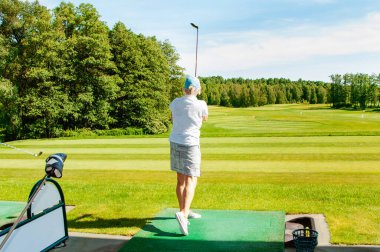 Profesyonel golf sahasında golf oyuncusu. Golf sopasıyla vuruşan golfçü.