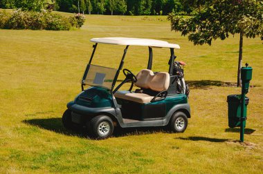 Golf sahasında güneşli bir golf arabası..