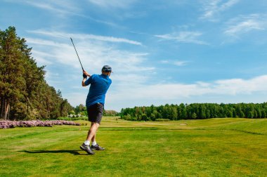 Profesyonel golf sahasında golf oyuncusu. Golf sopasıyla vuruşan golfçü.