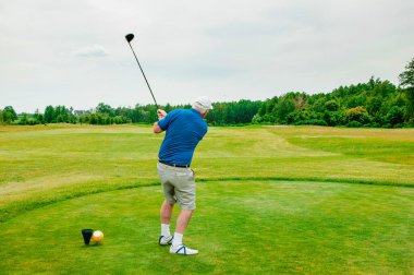 Profesyonel golf sahasında golf oyuncusu. Golf sopasıyla vuruşan golfçü.