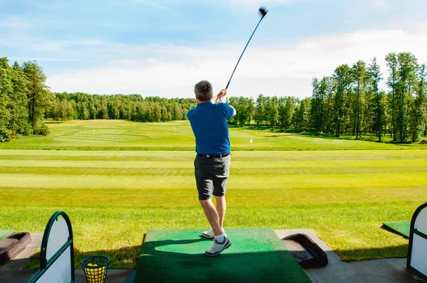 Profesyonel golf sahasında golf oyuncusu. Golf sopasıyla vuruşan golfçü.