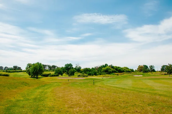 Yeşil golf sahası ve mavi bulutlu gökyüzü. Avrupa manzarası